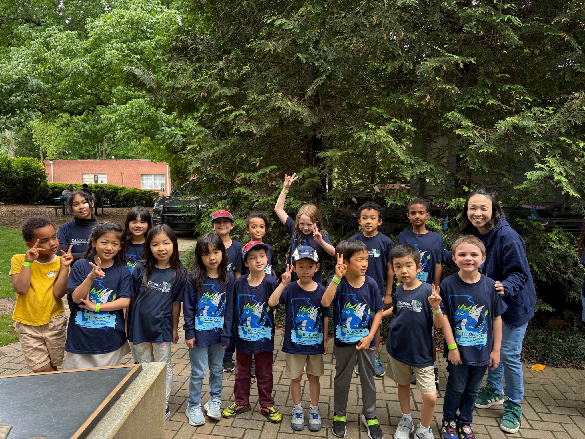 Group of children and adults wearing dark blue tshirts at an outdoor Children's Day festival in Norcross, Georgia