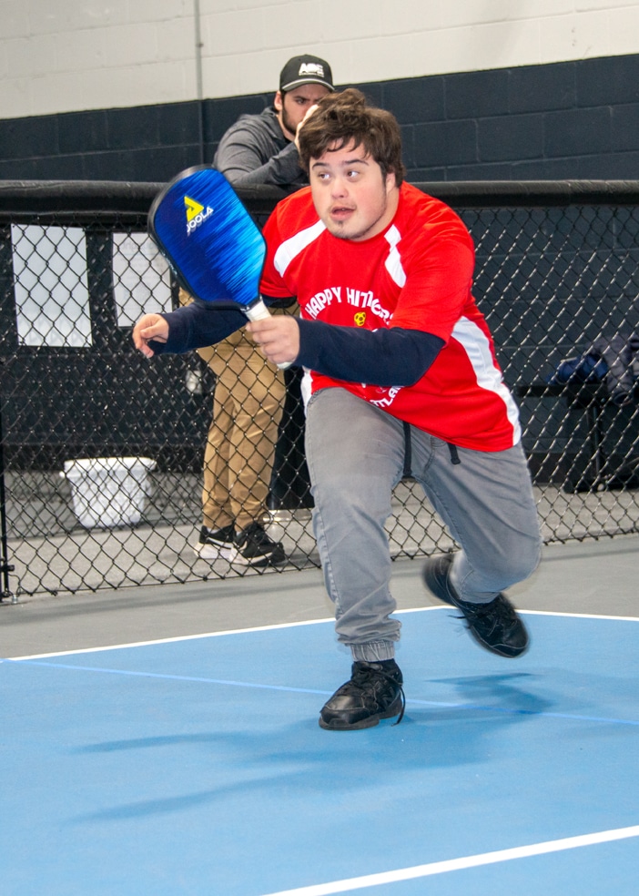 Male Special Olympics pickleball athlete on the court during practice