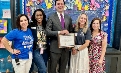 Four women and one man standing in front of a colorful wall at an elementary school for Exceptional Children's Week