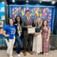 Four women and one man standing in front of a colorful wall at an elementary school for Exceptional Children's Week