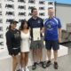 GA State Rep. Scott Hilton stands with two coaches and the manager of a Special Olympics of Georgia pickleball team, awarding House Resolution 700 commending them for their work.