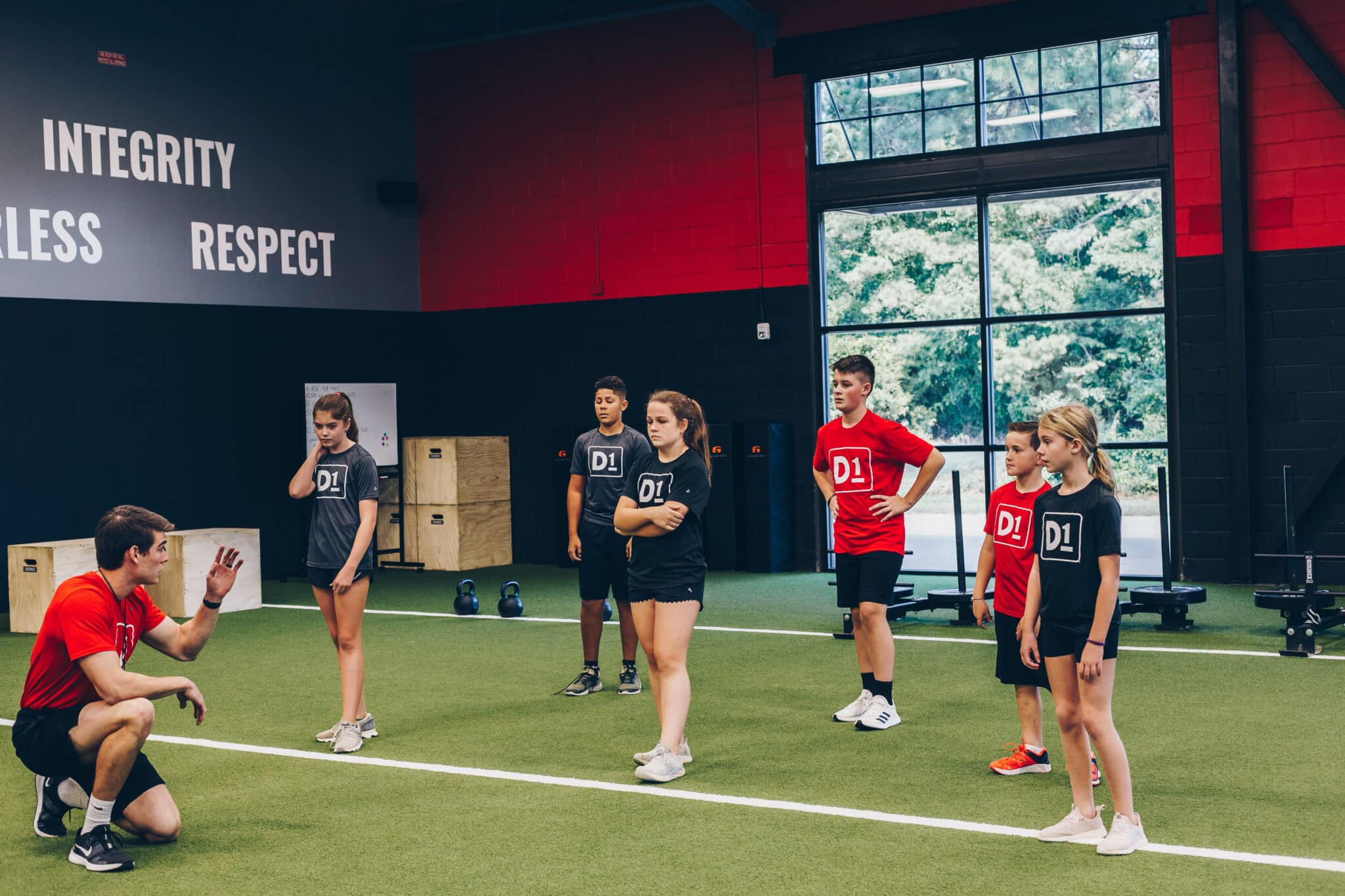Young male and female teen athletes at an indoor fitness facility.