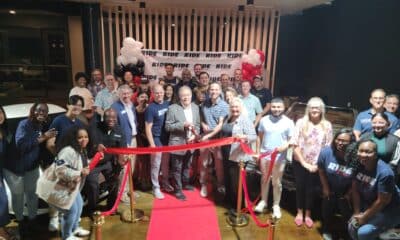 A group of people at an indoor ribbon cutting ceremony for Ride Lounge