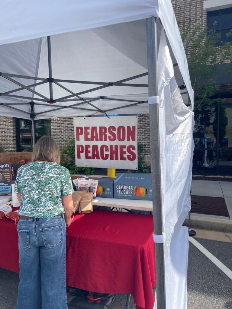 Pearson Farm Peaches booth at an outdoor farmers market