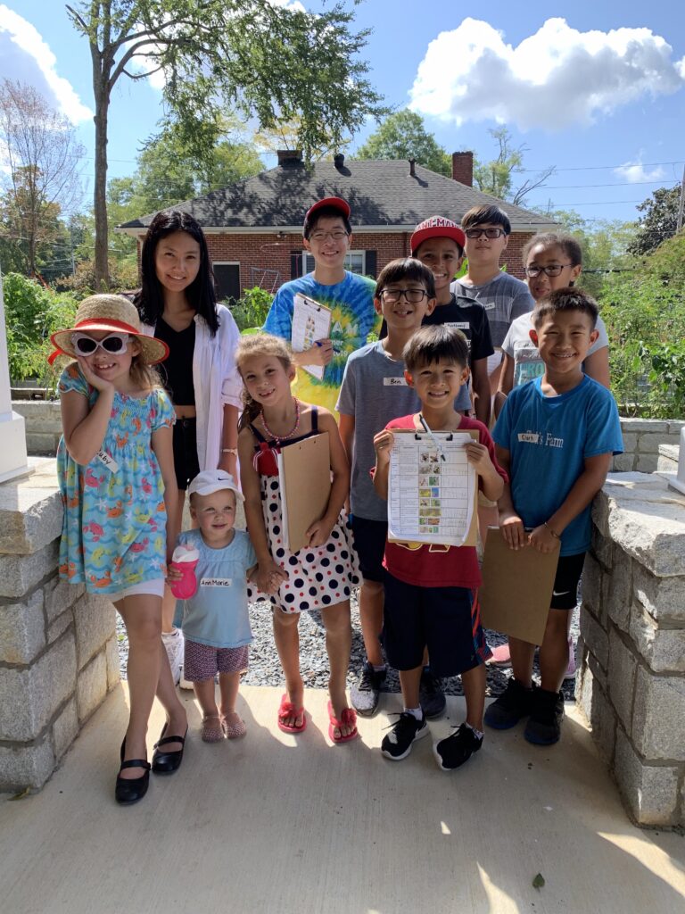 A group of kids gathered together for an outdoor garden class