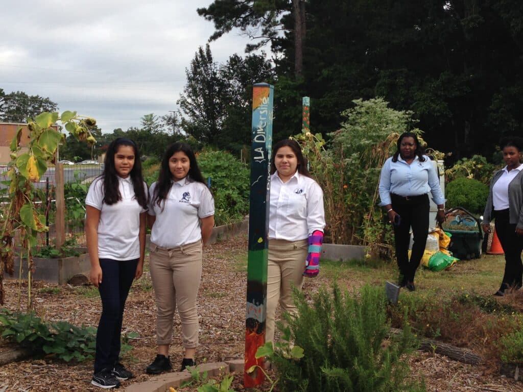 A group of young kids and one adult in a school garden