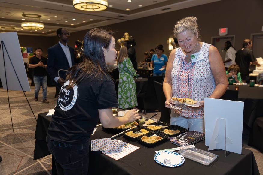 A staff member from Kumo Sushi in Peachtree Corners is handing out samples of food at the Taste of Peachtree Corners event in 2025.